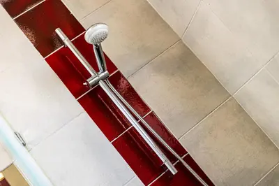 a shower stall with a red door in a bathroom at Ground floor with direct access to swimming pool in Albufeira