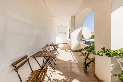 a room with two tables and chairs and an archway at Ground floor with direct access to swimming pool in Albufeira