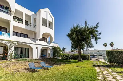 two blue chairs in front of a building at Ground floor with direct access to swimming pool in Albufeira