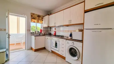 a kitchen with a washer and dryer in it at Golfview Apartment in Quarteira