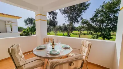 a dining room with a table and chairs and a window at Golfview Apartment in Quarteira