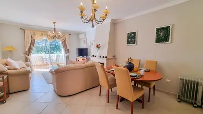 a living room with a table and a couch at Golfview Apartment in Quarteira