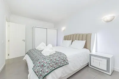 a white bedroom with a bed with towels on it at Quiet & Sea in Albufeira