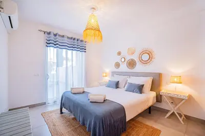 a bedroom with a large bed and a chandelier at Vitismar Praia Algarve in Guia