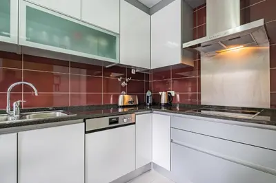 a kitchen with white cabinets and a sink at Vitismar Praia Algarve in Guia
