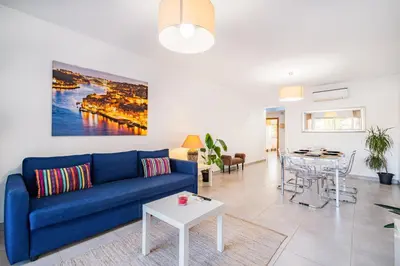 a living room with a blue couch and a table at Vitismar Praia Algarve in Guia