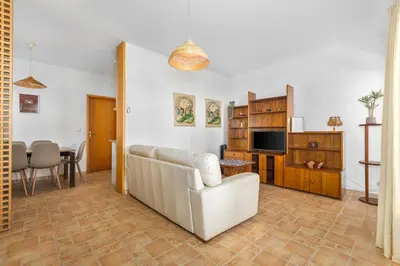 a living room with a couch and a chair and a television at Bright 3BDR Vilamoura Retreat Flat by LovelyStay in Quarteira