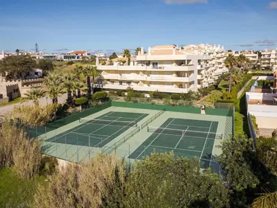 an aerial view of a tennis court in front of a building at Palm Breeze Retreat in Albufeira w Pool and Balcony by Lisbeyond in Albufeira