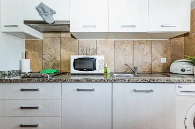 a kitchen with a microwave and a sink at 5-minute walk to Aveiros Beach in Albufeira