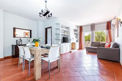 a kitchen and living room with a table and chairs at 5-minute walk to Aveiros Beach in Albufeira