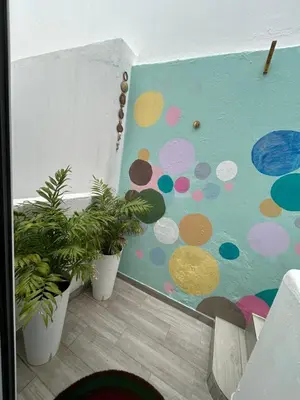 a room with two potted plants and a wall with polka dots at Dolce Faro Niente Guest House in Faro