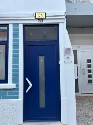 a blue door on a building with a sign above it at Dolce Faro Niente Guest House in Faro