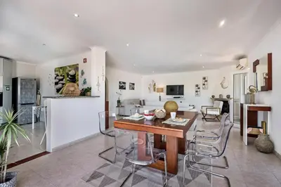 a kitchen and living room with a table and chairs at Lovely Vacation Villa In Loulé in Loulé