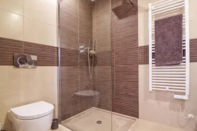 a bathroom with a glass shower with a toilet at Lovely Vacation Villa In Loulé in Loulé