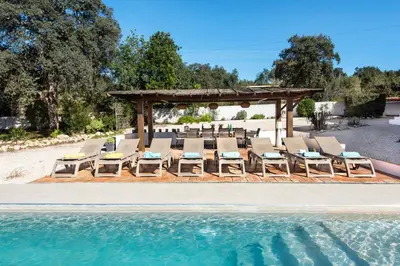 an outdoor dining room with a long table and chairs at Lovely Vacation Villa In Loulé in Loulé