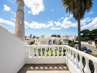 a house with a palm tree in the yard at Akivillas Albufeira Now in Olhos de Água