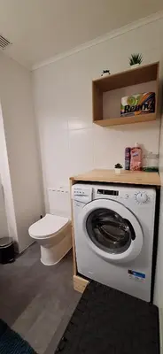 a bathroom with a washing machine and a toilet at Soleil- Apartamento Central e espaçoso in Albufeira