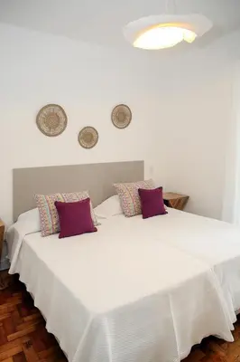 a bedroom with a large white bed with red pillows at Casa Tomás in Faro