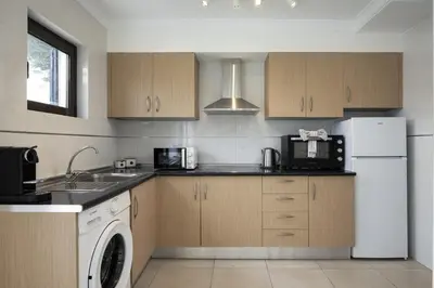 a kitchen with a white refrigerator and a dishwasher at Marina Búzios I & II - Vilamoura Marina by HD in Vilamoura