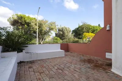 a brick patio with a fence and trees at Marina Búzios I & II - Vilamoura Marina by HD in Vilamoura