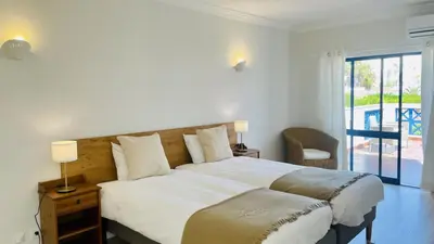 a bedroom with two beds and a balcony at Jardim da Oura by Check-in, Portugal in Albufeira