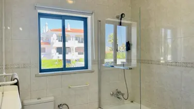 a bathroom with a glass shower with a window at Jardim da Oura by Check-in, Portugal in Albufeira
