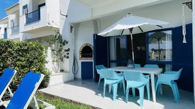 a table and chairs with an umbrella on a patio at Jardim da Oura by Check-in, Portugal in Albufeira