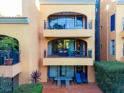 a apartment building with a balcony with a picnic table at F5 Vila Sol G Pool & Golf in Vilamoura in Quarteira