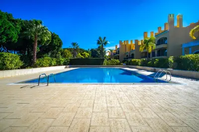 a swimming pool in front of a building at F5 Vila Sol AI Pool & Golf in Vilamoura in Quarteira