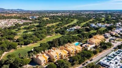 an aerial view of a city with houses and trees at F5 Vila Sol AI Pool & Golf in Vilamoura in Quarteira