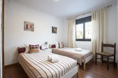 a bedroom with two beds and a chair at Ancora Mar - Vilamoura Marina by HD in Vilamoura