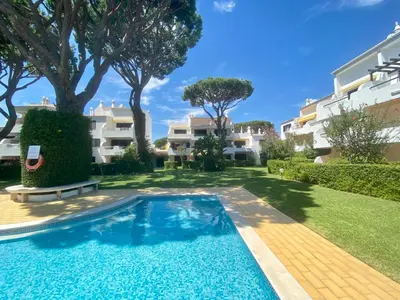 a swimming pool in a yard next to a building at Solar Vilamoura Relaxing Apartment Stay in Quarteira