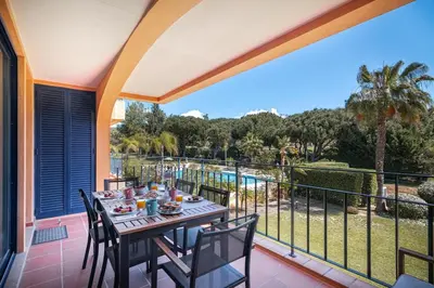 a table on a balcony with a view of a pool at F5 Vila Sol Q Pool & Golf in Vilamoura in Quarteira