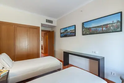 a bedroom with two beds and a tv on the wall at F5 Vila Sol Q Pool & Golf in Vilamoura in Quarteira