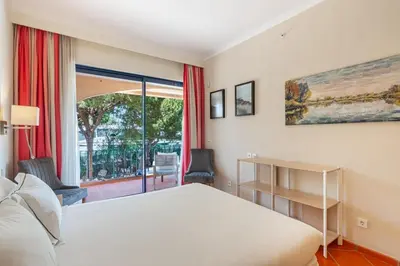 a bedroom with a white bed and a balcony at F5 Vila Sol Q Pool & Golf in Vilamoura in Quarteira