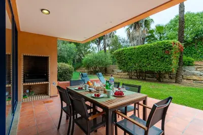 a patio with a wooden table and chairs at F5 Vila Sol AP Pool & Golf in Vilamoura in Quarteira