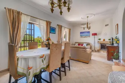 a dining room with a table and a living room at Villa Mario - Swimming pool - WIFI - BY BEDZY in Albufeira
