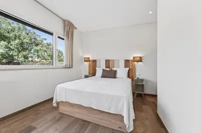 a bedroom with a white bed and a large window at Villa Joya in Almancil