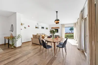 a dining room and living room with a table and chairs at Villa Joya in Almancil