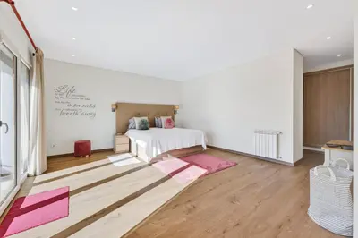 a bedroom with a white bed and pink rugs at Villa Joya in Almancil