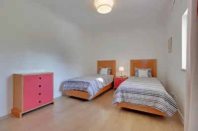 a bedroom with two beds and a dresser at Las Palmeiras Vilamoura in Quarteira