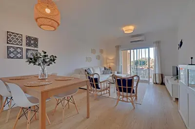 a kitchen and dining room with a table and chairs at Las Palmeiras Vilamoura in Quarteira