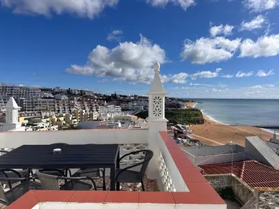 a balcony with a table and a view of the beach at Al-Gharb House - Vista Mar in Albufeira