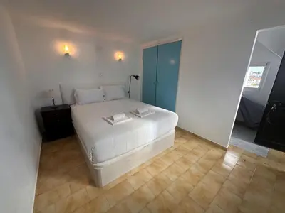 a bedroom with a white bed and a mirror at Al-Gharb House - Vista Mar in Albufeira