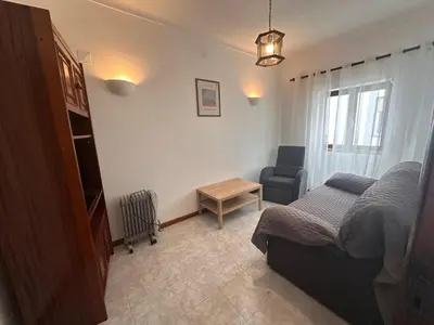 a bedroom with a bed and a chair at Al-Gharb House - Vista Mar in Albufeira
