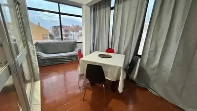 a table and a chair in a room with a window at Blife Josya private apartment at Faro beach in Faro