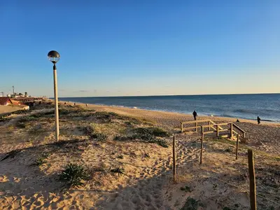 a beach with a light pole and the ocean at Blife Josya private apartment at Faro beach in Faro