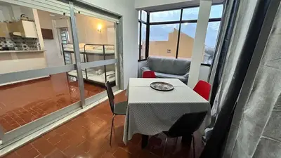 a small table and chairs in a room with a balcony at Blife Josya private apartment at Faro beach in Faro