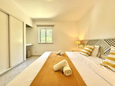 a bedroom with a large bed with towels on it at Albufeira Balaia Golf Vilage 8 With Pool by Homing in Albufeira