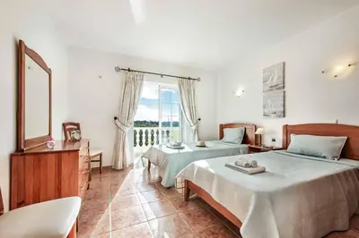 a bedroom with two beds and a large window at Villa Portela in Loulé